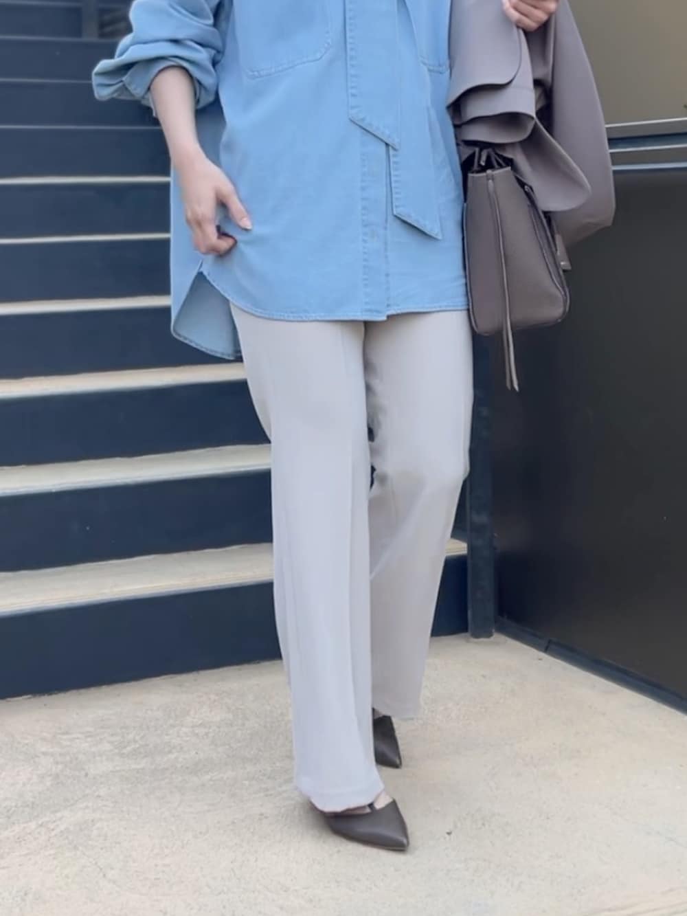 ブルー系のシャツ/ブラウス、ブラウン系のトートバッグ、ベージュ系のその他パンツを着用したレディースの冬コーディネートの4枚目の写真