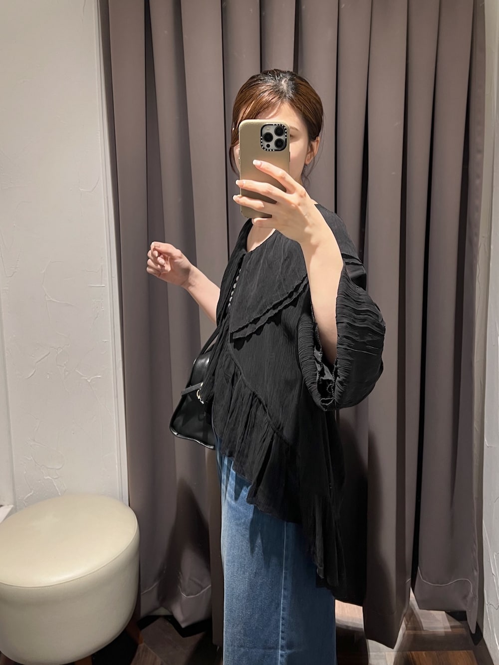 ブラック系のシャツ/ブラウス、ブルー系のデニムパンツ、ブラック系のパンプスを着用したレディースの冬コーディネートの6枚目の写真