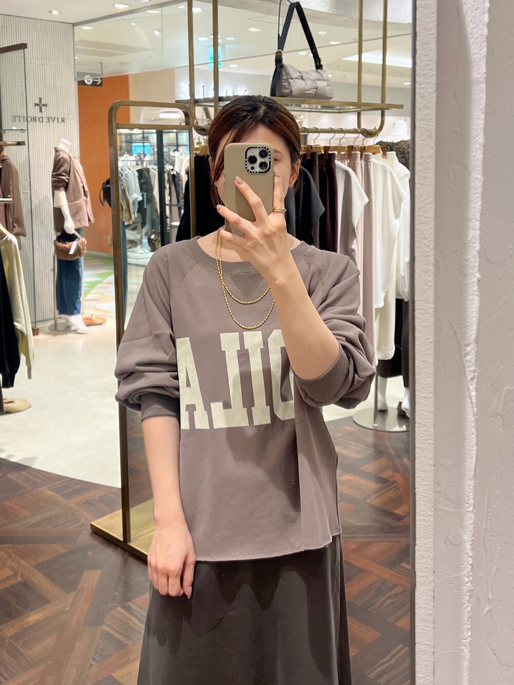 ブラウン系のスウェット、ブラウン系のスカート、ブラウン系のショルダーバッグを着用したレディースの秋コーディネートの5枚目の写真