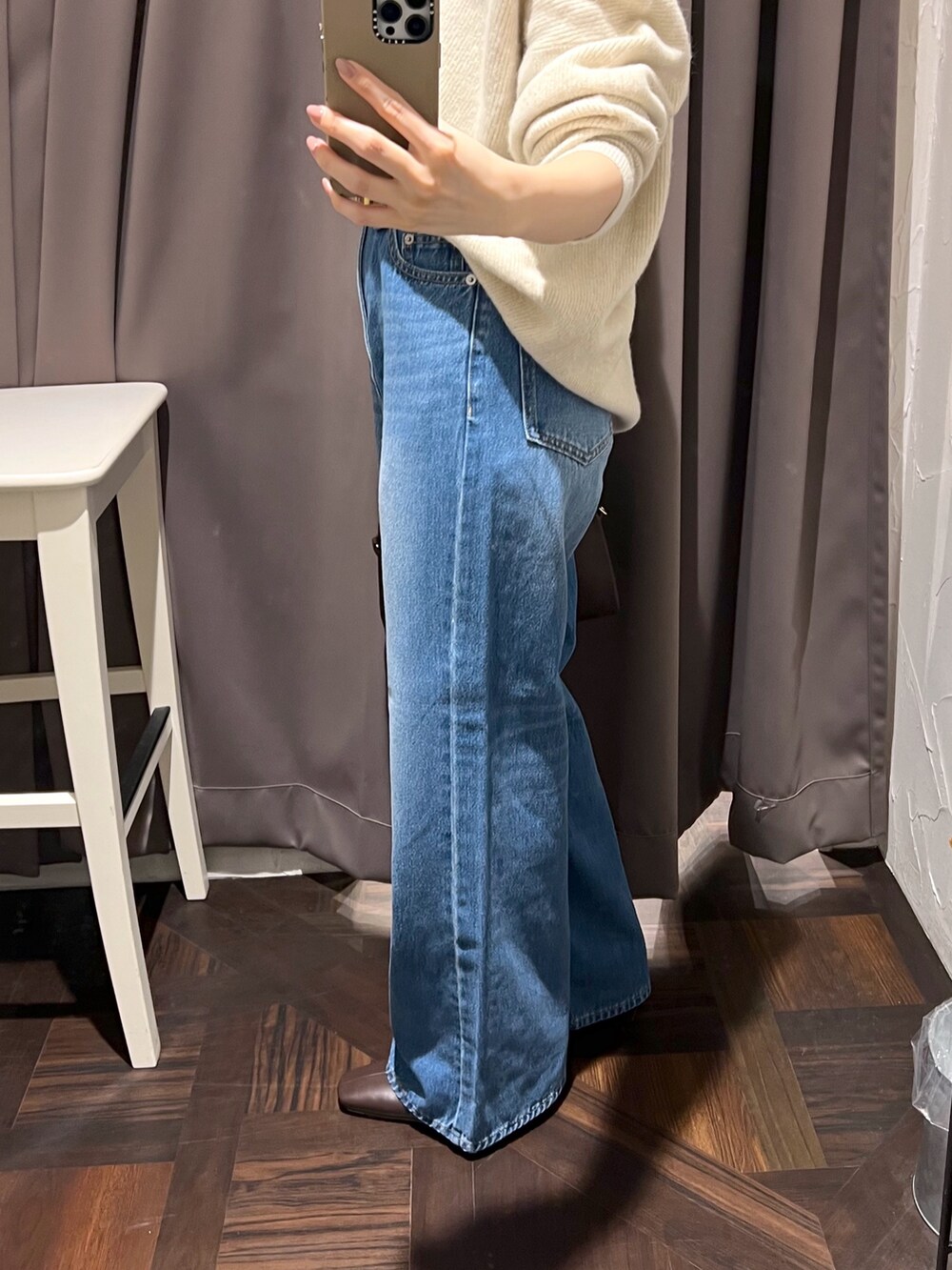 ベージュ系のニット/セーター、ブルー系のデニムパンツ、ブラウン系のボストンバッグを着用したレディースの秋コーディネートの9枚目の写真