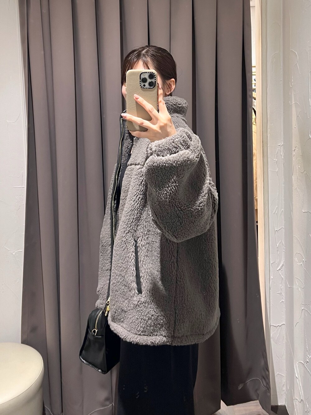 グレー系のその他アウター、ブラック系のワンピース、ブラック系のボストンバッグを着用したレディースの秋コーディネートの6枚目の写真