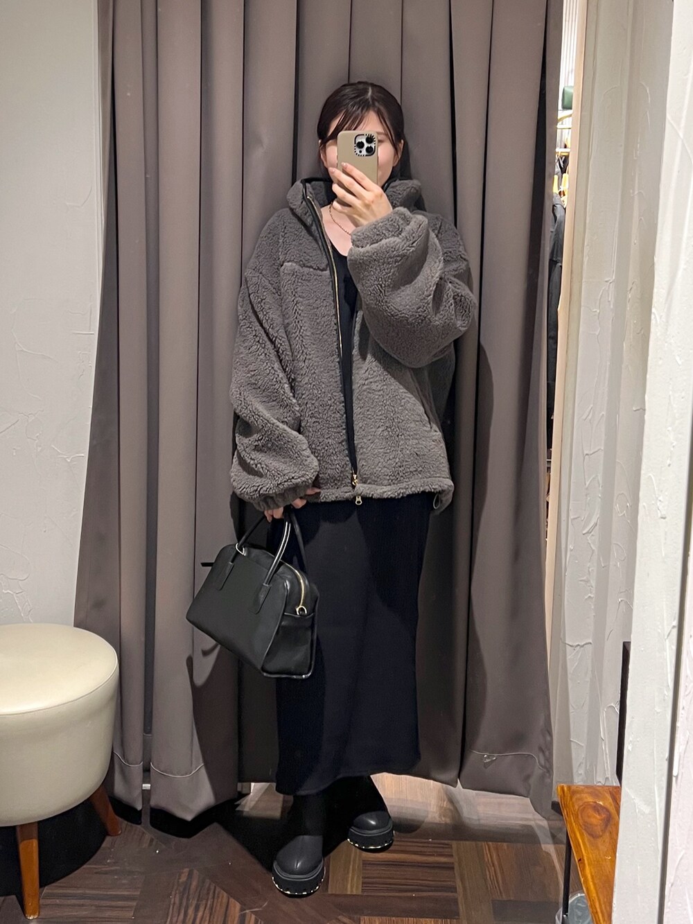 グレー系のその他アウター、ブラック系のワンピース、ブラック系のボストンバッグを着用したレディースの秋コーディネートの2枚目の写真