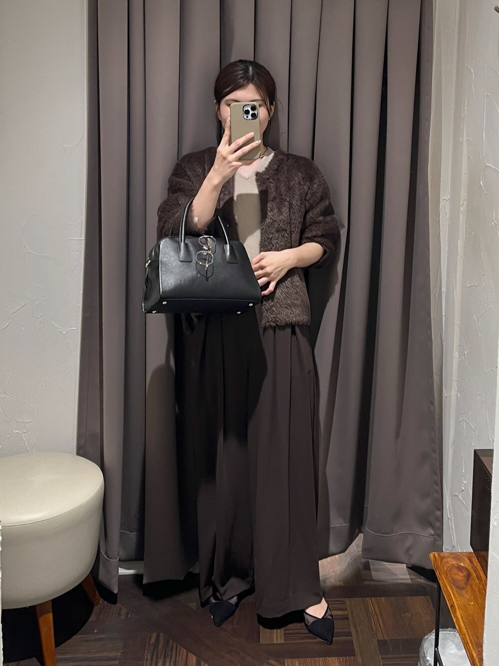 ブラウン系のカーディガン/ボレロ、ブラウン系のスラックス、ブラック系のパンプスを着用したレディースの冬コーディネートの2枚目の写真