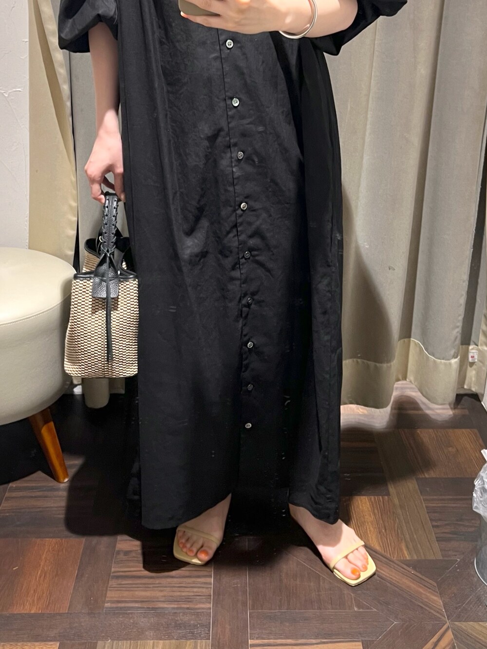 ブラック系のワンピース、ベージュ系のサンダル、ブラック系のハンドバッグを着用したレディースの夏コーディネートの5枚目の写真