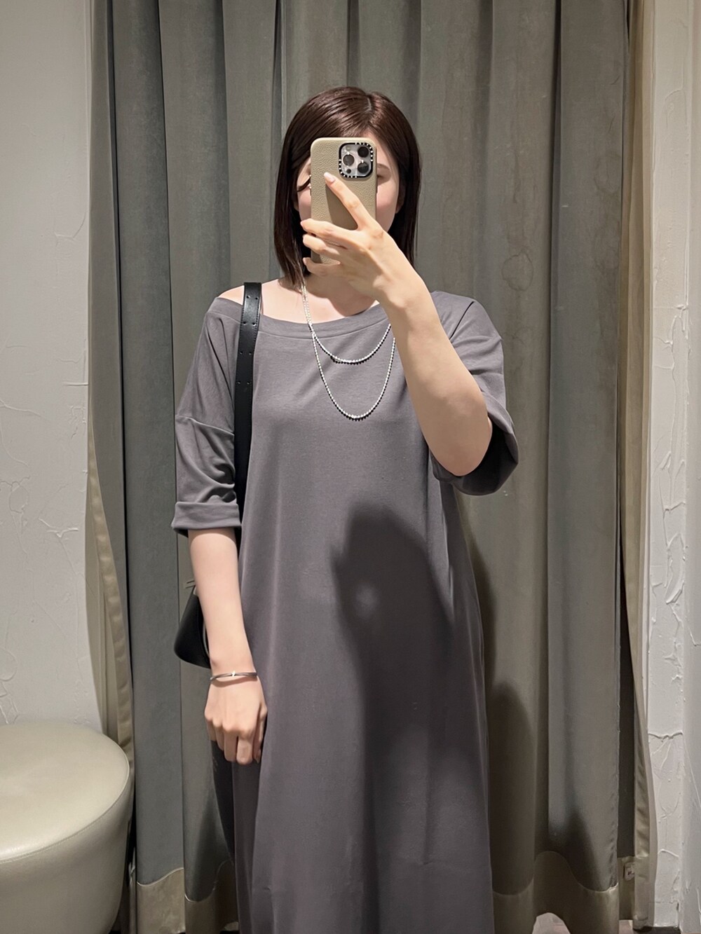 グレー系のワンピース、シルバー系のネックレス、シルバー系のブレスレットを着用したレディースの夏コーディネートの4枚目の写真