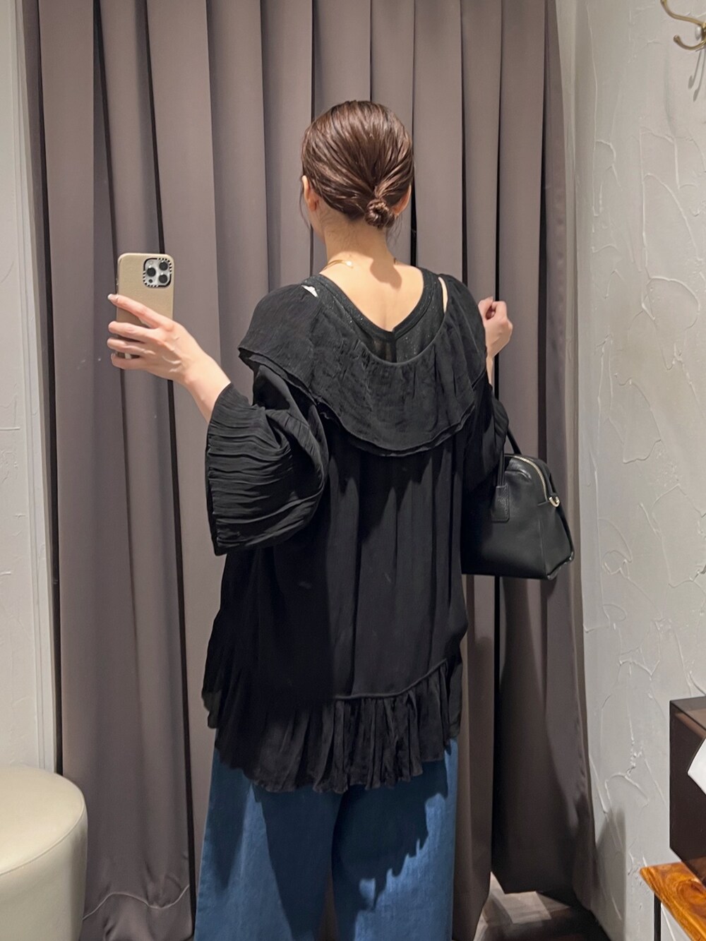 ブラック系のシャツ/ブラウス、ブルー系のデニムパンツ、ブラック系のパンプスを着用したレディースの冬コーディネートの7枚目の写真