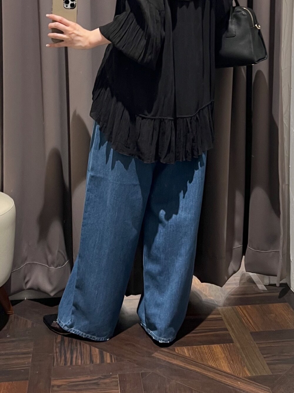 ブラック系のシャツ/ブラウス、ブルー系のデニムパンツ、ブラック系のパンプスを着用したレディースの冬コーディネートの10枚目の写真