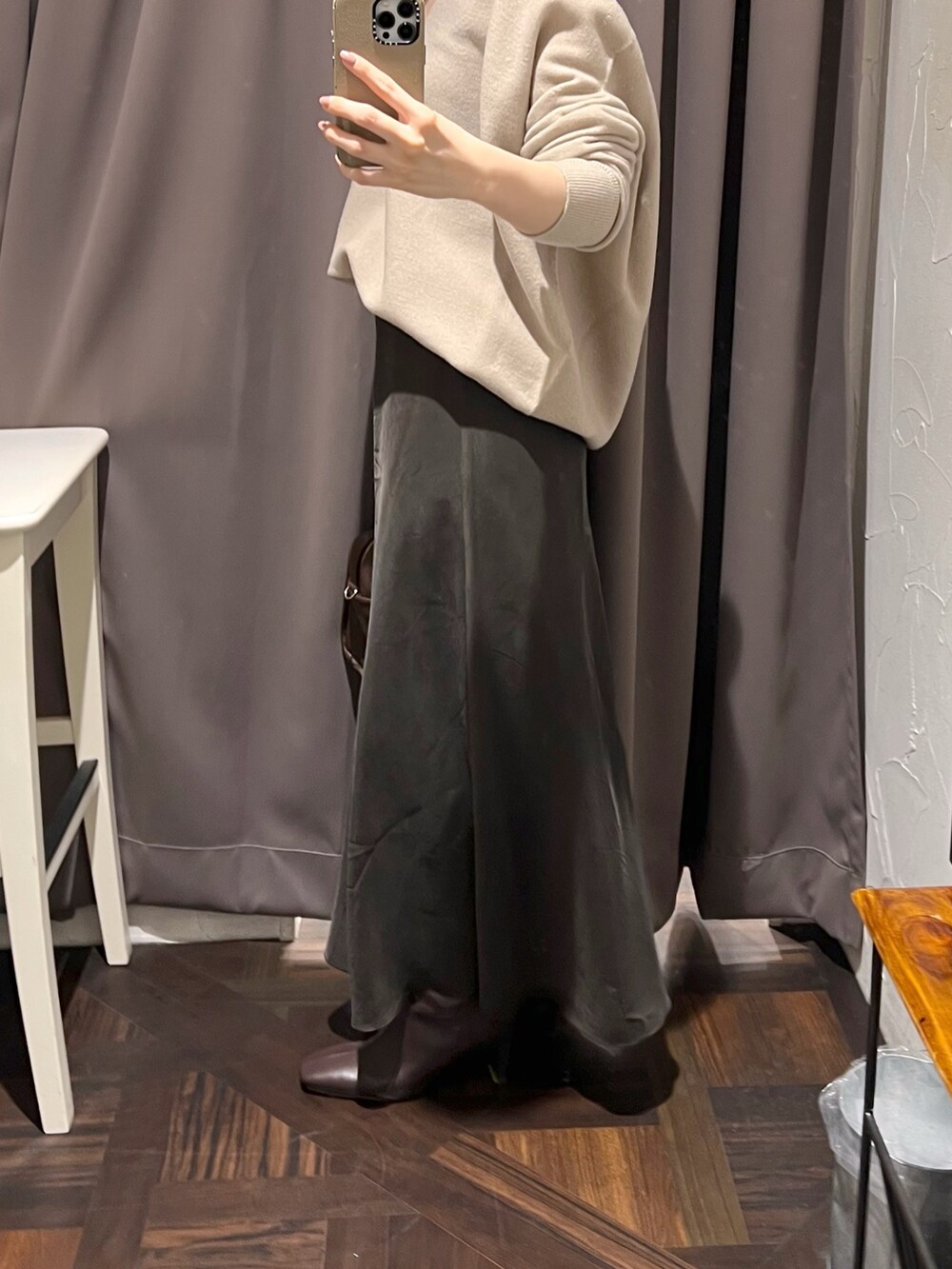 ベージュ系のニット/セーター、ブラウン系のスカート、ブラウン系のボストンバッグを着用したレディースの秋コーディネートの9枚目の写真