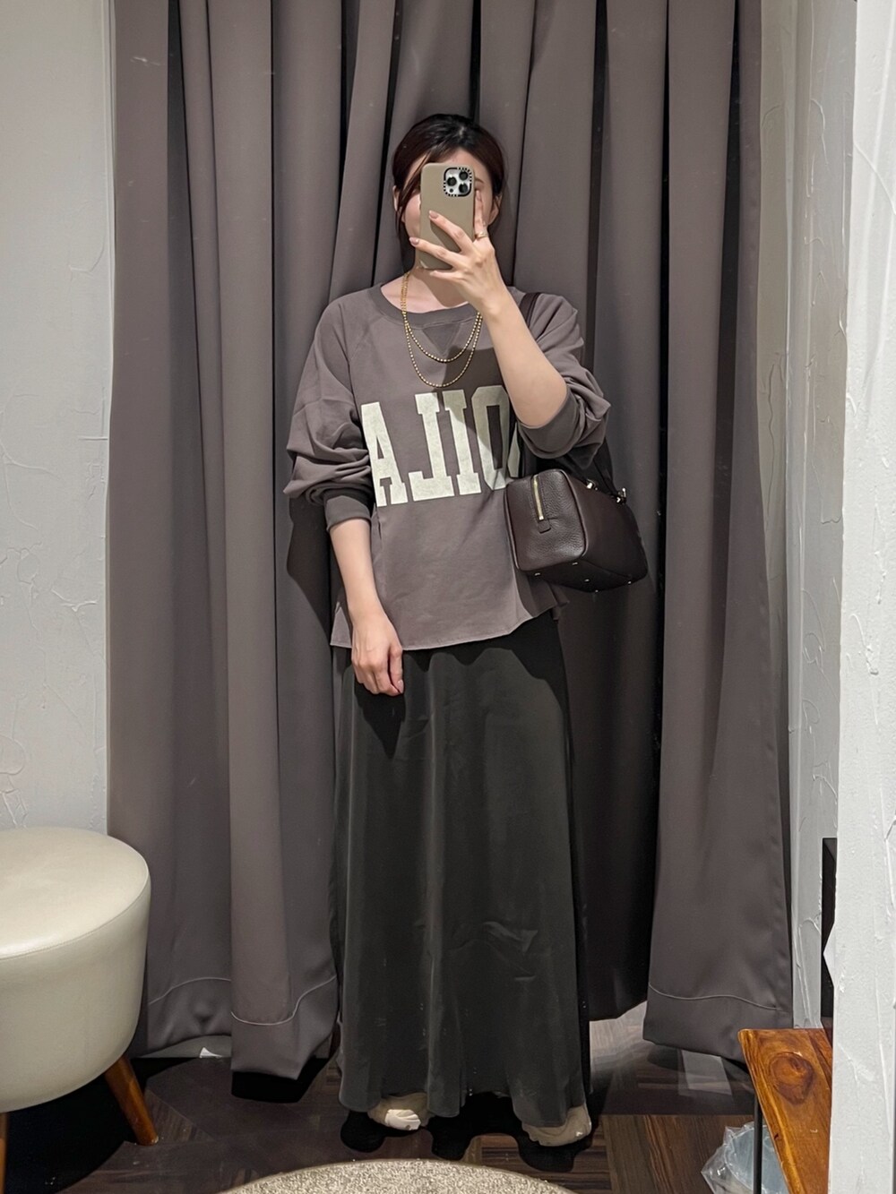 ブラウン系のスウェット、ブラウン系のスカート、ブラウン系のショルダーバッグを着用したレディースの秋コーディネートの2枚目の写真