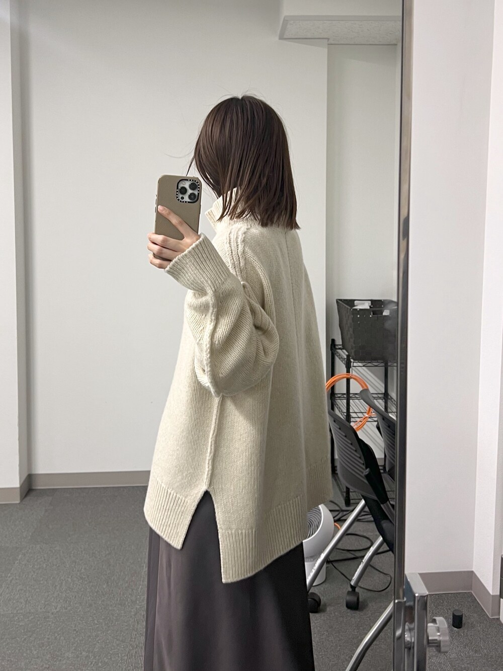 ベージュ系のボストンバッグ、ホワイト系のニット/セーター、ブラウン系のスカートを着用したレディースの秋コーディネートの6枚目の写真