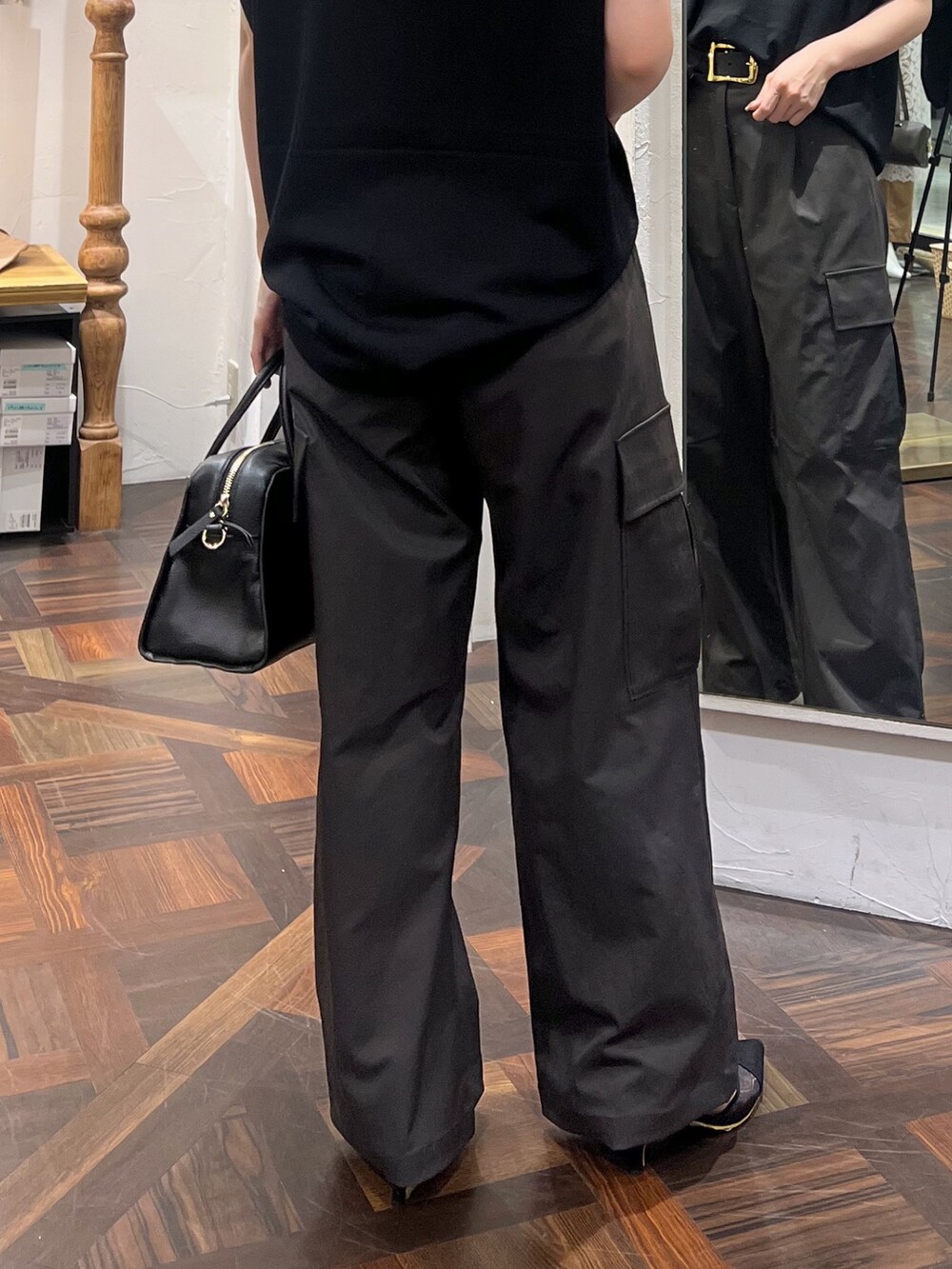 ブラック系のニット/セーター、ブラック系のボストンバッグ、ブラック系のパンプスを着用したレディースの秋コーディネートの10枚目の写真