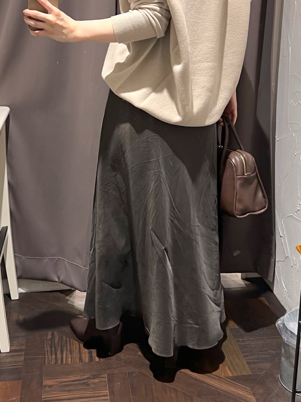 ベージュ系のニット/セーター、ブラウン系のスカート、ブラウン系のボストンバッグを着用したレディースの秋コーディネートの10枚目の写真