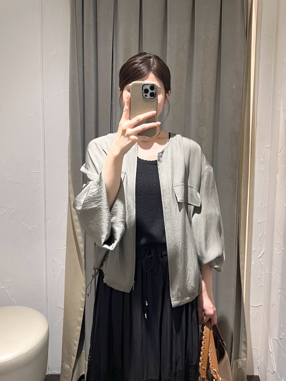 グリーン系のブルゾン、ブラック系のニット/セーター、ブラウン系のトートバッグを着用したレディースの夏コーディネートの4枚目の写真