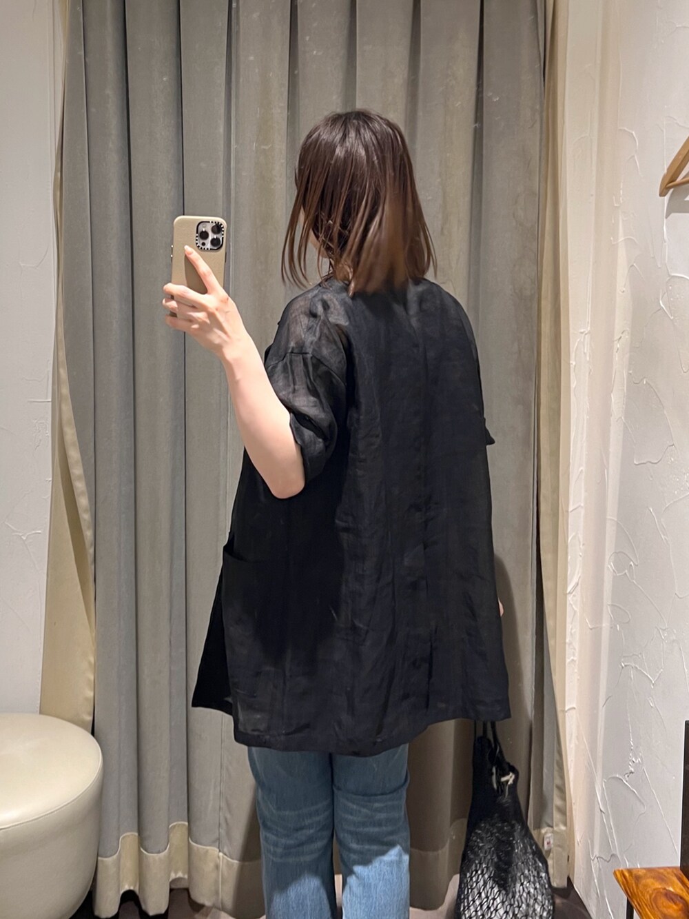 ブラック系のテーラードジャケット、ブルー系のデニムパンツ、ブラック系のサンダルを着用したレディースの夏コーディネートの5枚目の写真