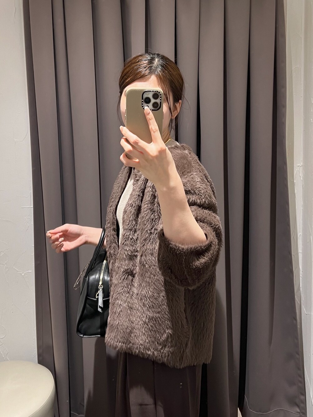 ブラウン系のカーディガン/ボレロ、ブラウン系のスラックス、ブラック系のパンプスを着用したレディースの冬コーディネートの6枚目の写真