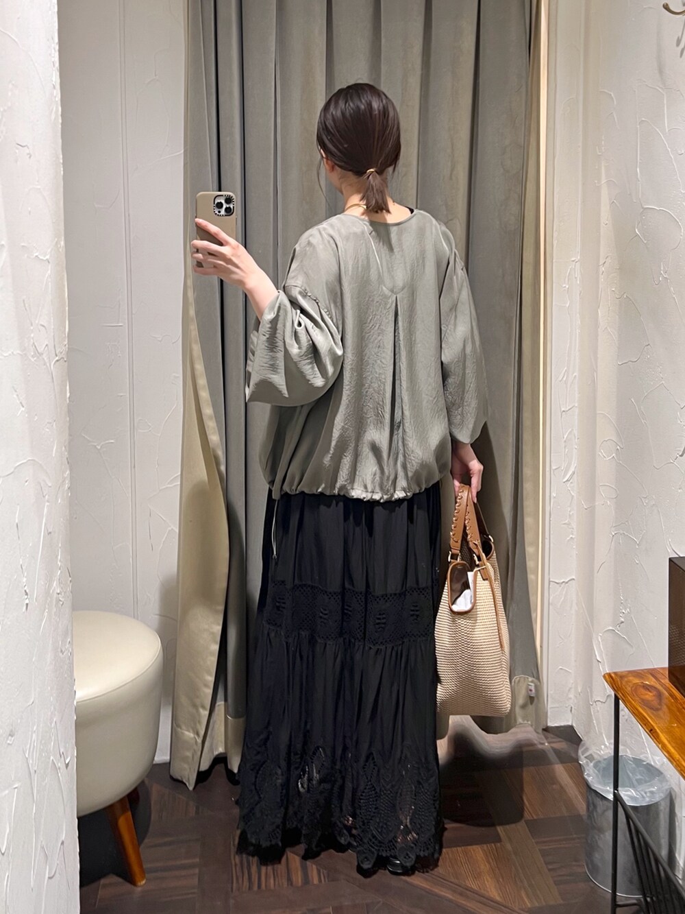 グリーン系のブルゾン、ブラック系のニット/セーター、ブラウン系のトートバッグを着用したレディースの夏コーディネートの3枚目の写真