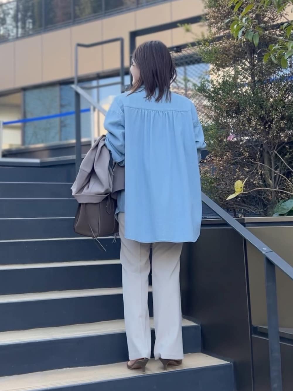 ブルー系のシャツ/ブラウス、ブラウン系のトートバッグ、ベージュ系のその他パンツを着用したレディースの冬コーディネートの2枚目の写真