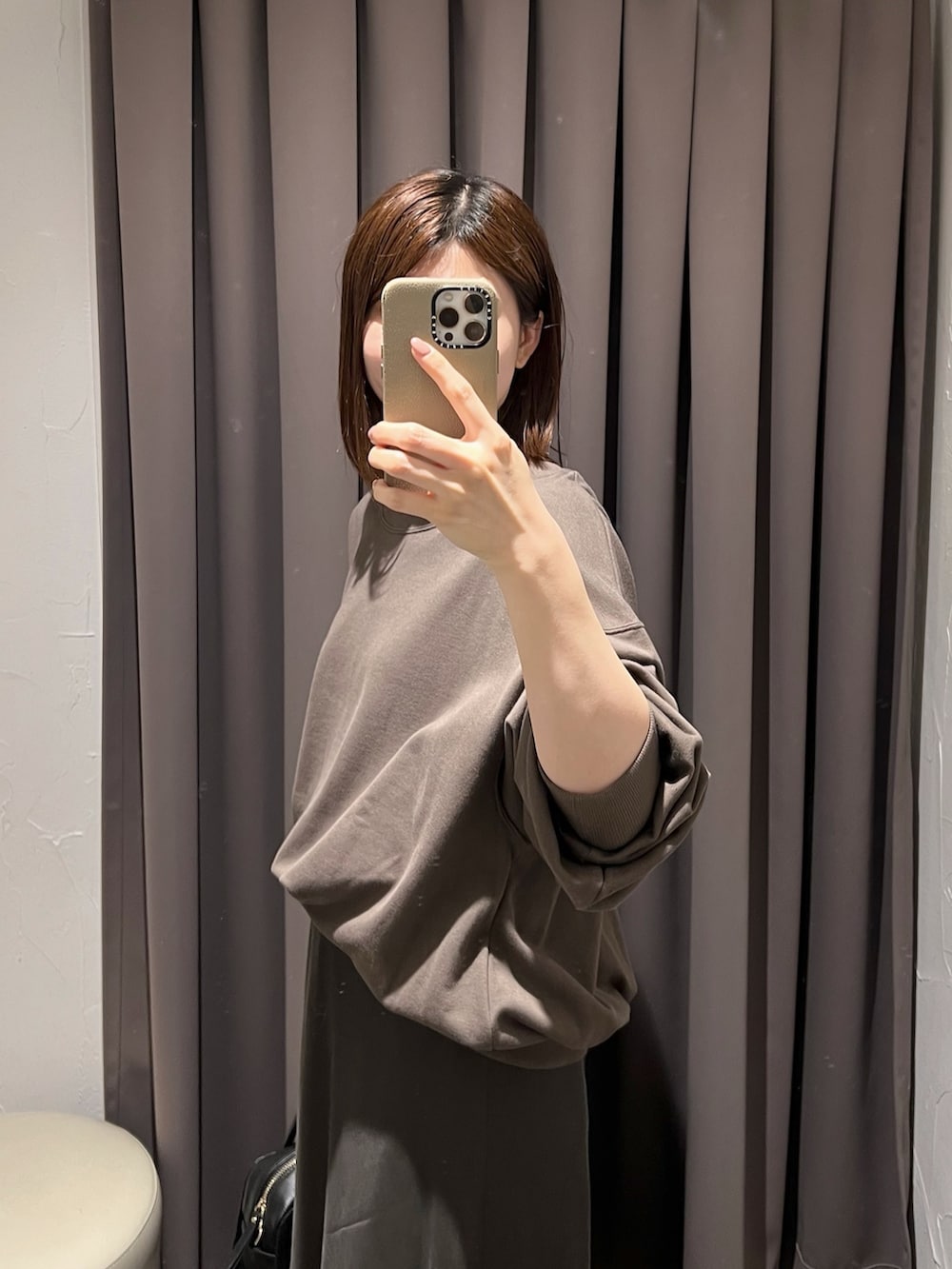 ブラウン系のスカート、ブラック系のボストンバッグ、ブラック系のパンプスを着用したレディースの冬コーディネートの5枚目の写真