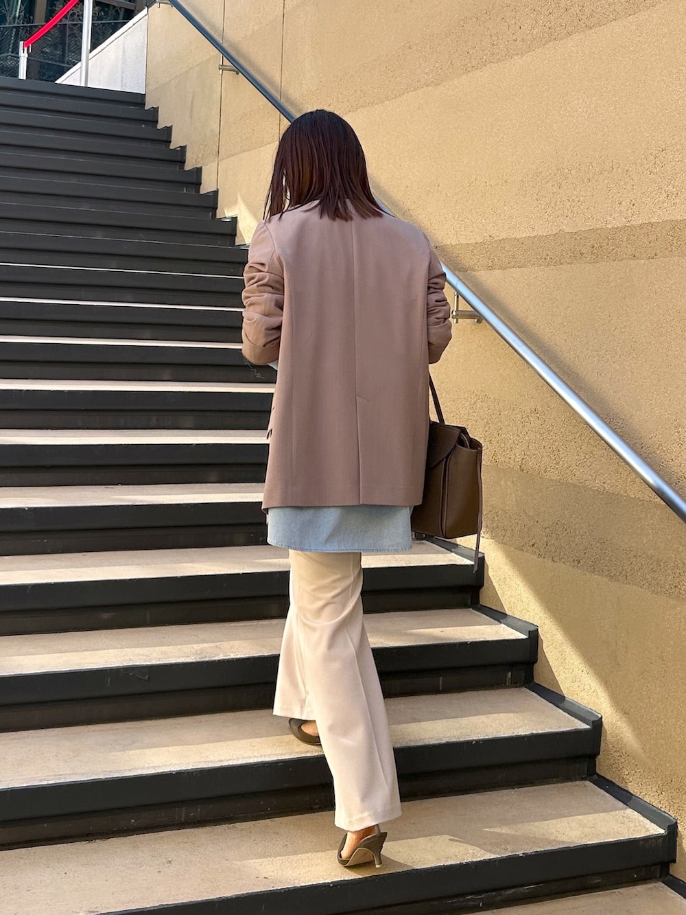 ブラウン系のテーラードジャケット、ブルー系のシャツ/ブラウス、ベージュ系のその他パンツを着用したレディースの冬コーディネートの3枚目の写真