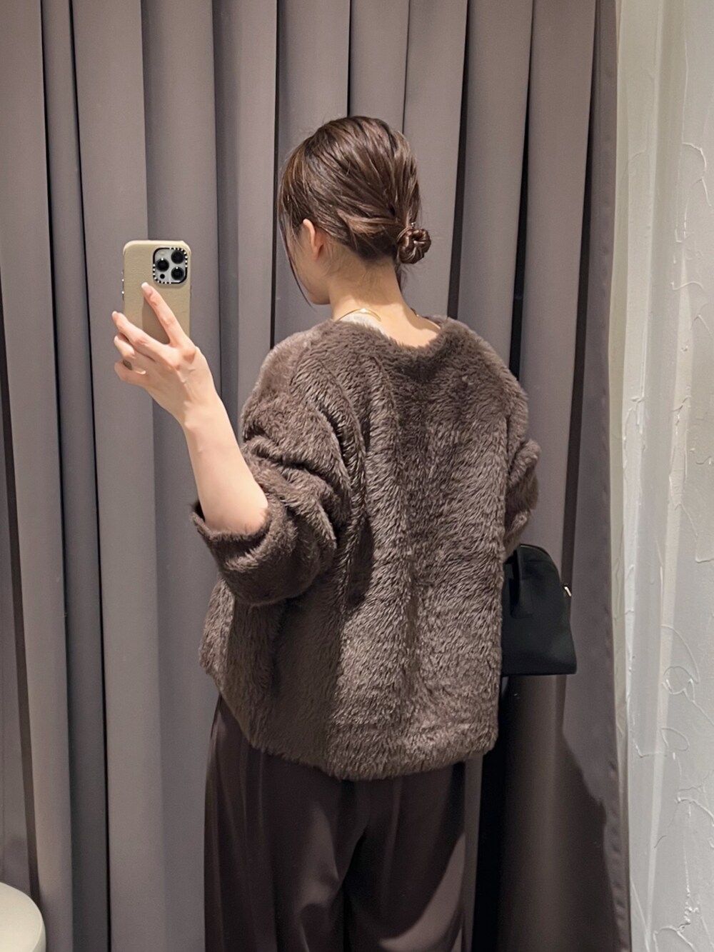 ブラウン系のカーディガン/ボレロ、ブラウン系のスラックス、ブラック系のパンプスを着用したレディースの冬コーディネートの7枚目の写真