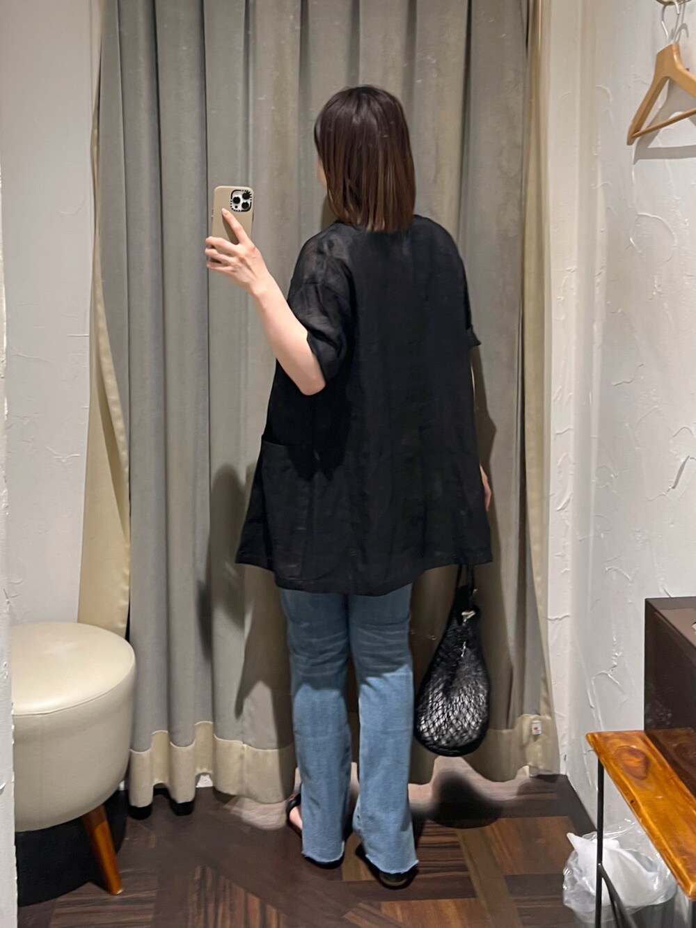 ブラック系のテーラードジャケット、ブルー系のデニムパンツ、ブラック系のサンダルを着用したレディースの夏コーディネートの3枚目の写真