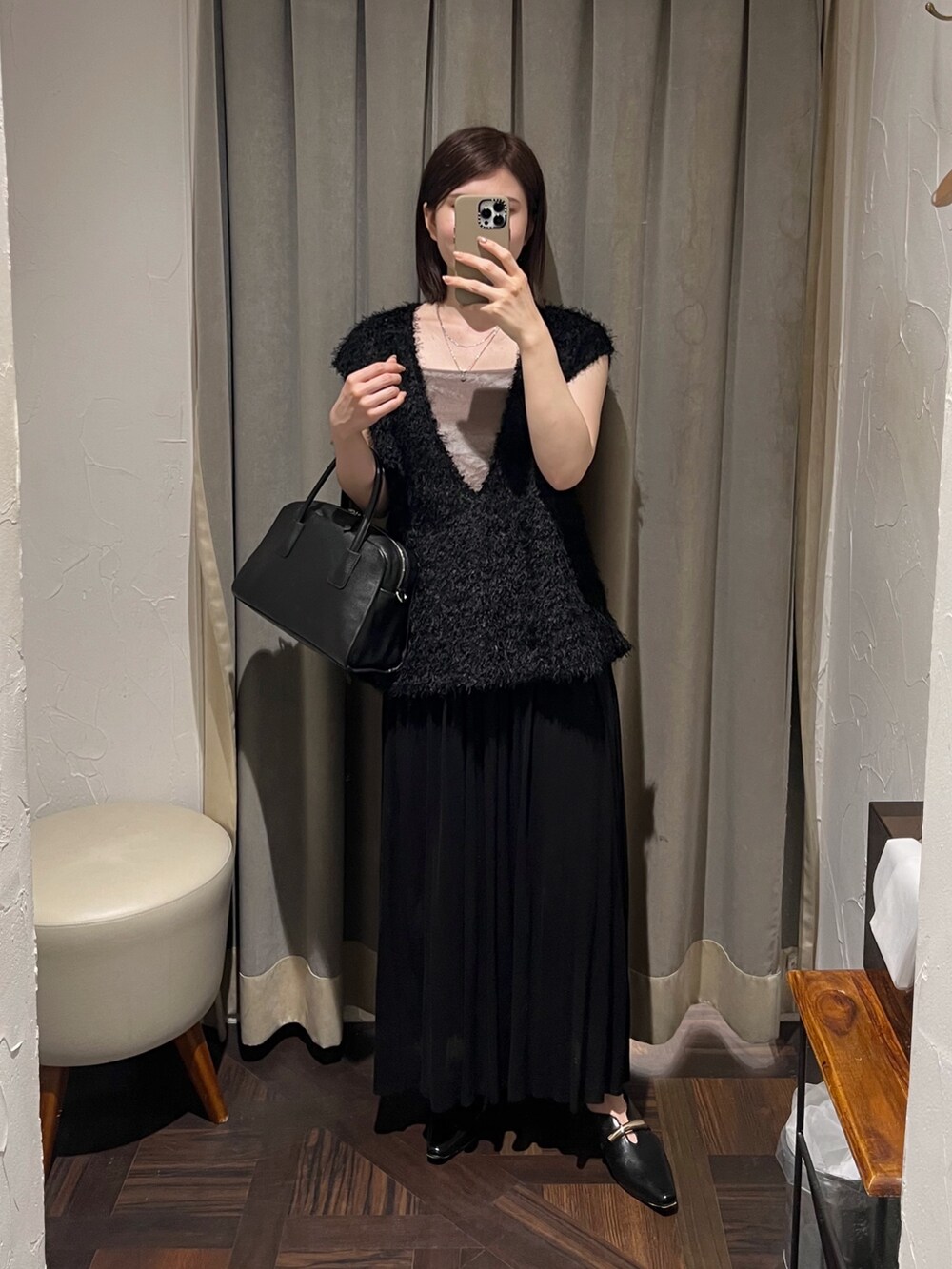 ブラック系のベスト、ブラック系のスカート、ブラック系のボストンバッグを着用したレディースの夏コーディネートの2枚目の写真