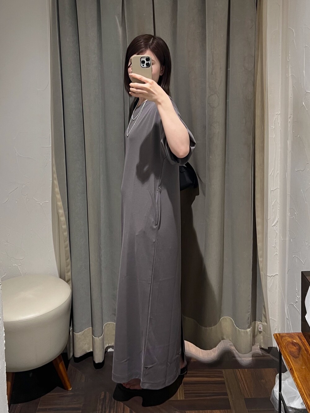 グレー系のワンピース、シルバー系のネックレス、シルバー系のブレスレットを着用したレディースの夏コーディネートの2枚目の写真