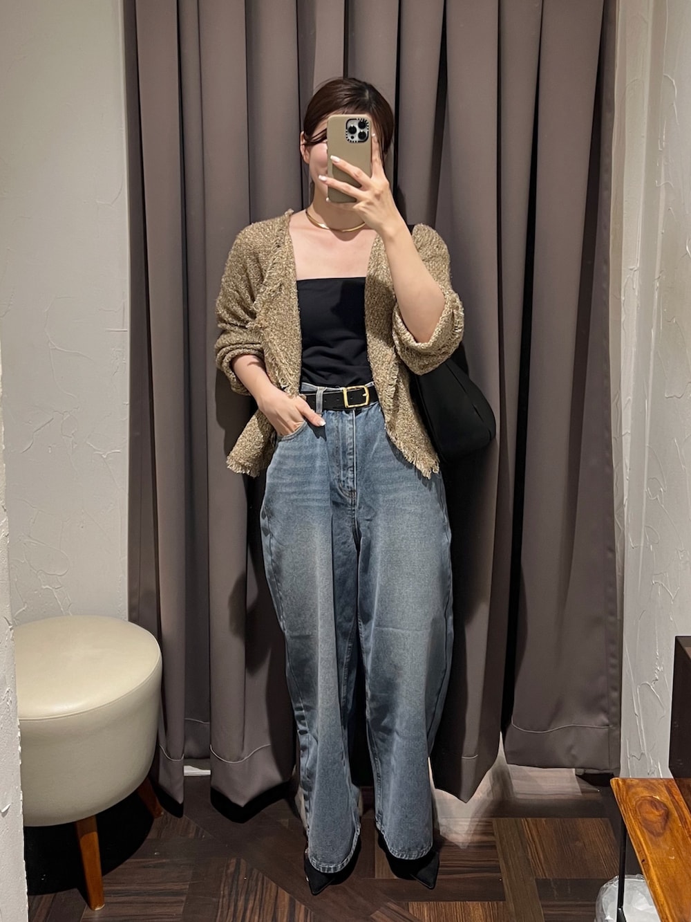 ベージュ系のカーディガン/ボレロ、ブルー系のデニムパンツ、ブラック系のショルダーバッグを着用したレディースの秋コーディネートの2枚目の写真