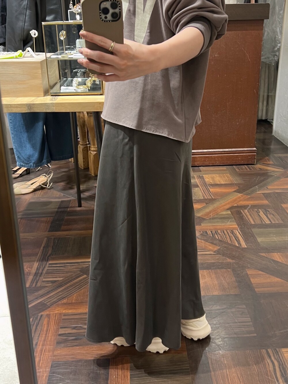 ブラウン系のスウェット、ブラウン系のスカート、ブラウン系のショルダーバッグを着用したレディースの秋コーディネートの10枚目の写真