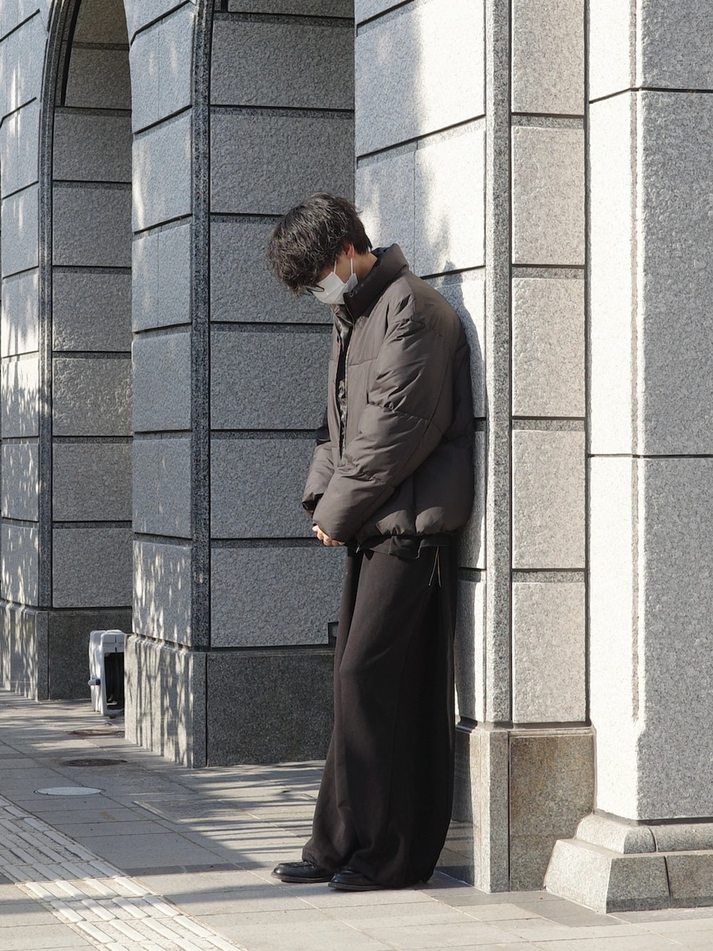 ブラック系のダウンジャケット/コート、ブラック系のスウェットパンツ、ブラック系のローファーを着用したメンズの秋コーディネートの2枚目の写真