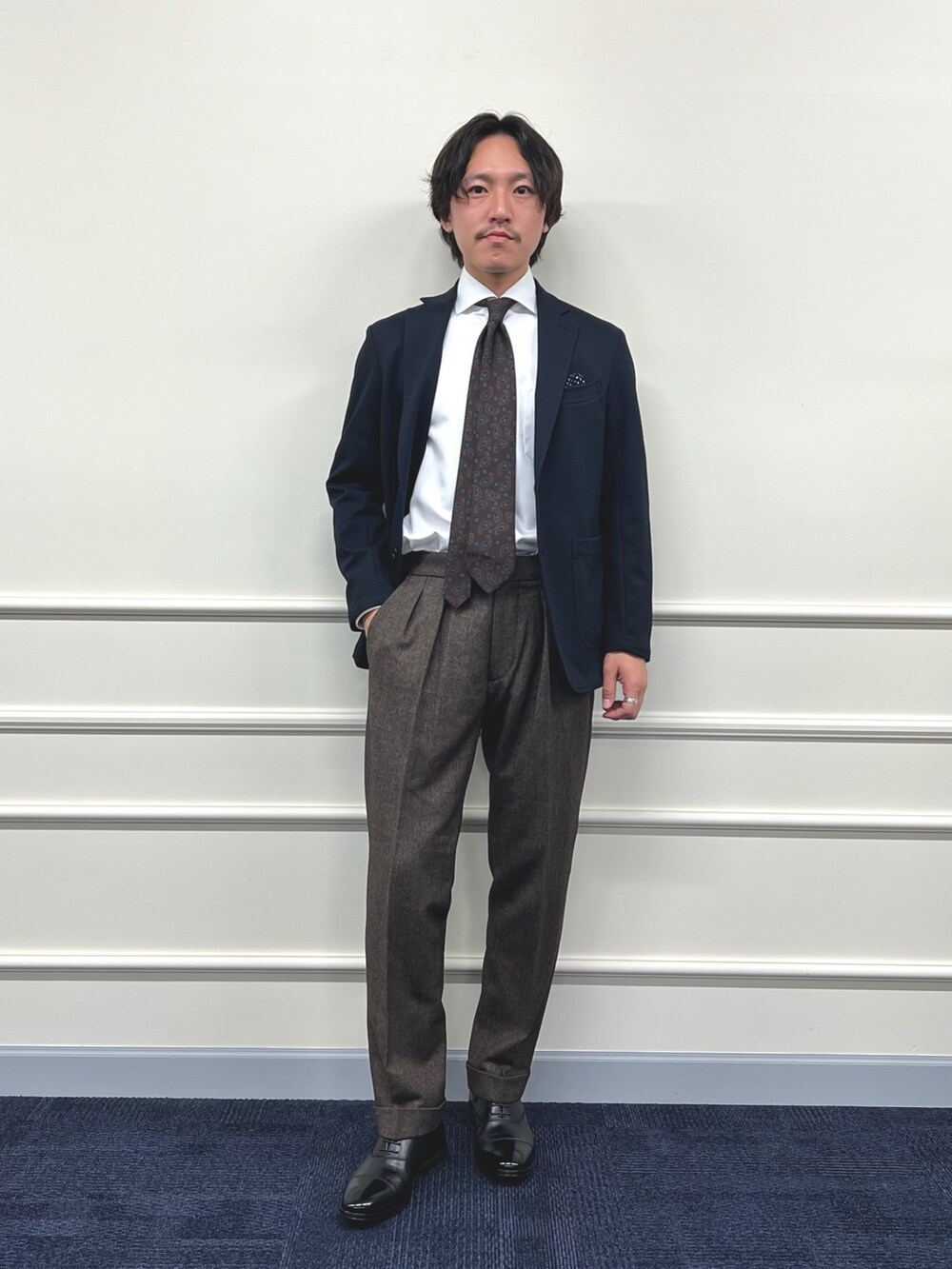 ブルー系のテーラードジャケット、ホワイト系のシャツ/ブラウス、ブラウン系のスラックスを着用したメンズの冬コーディネートの4枚目の写真
