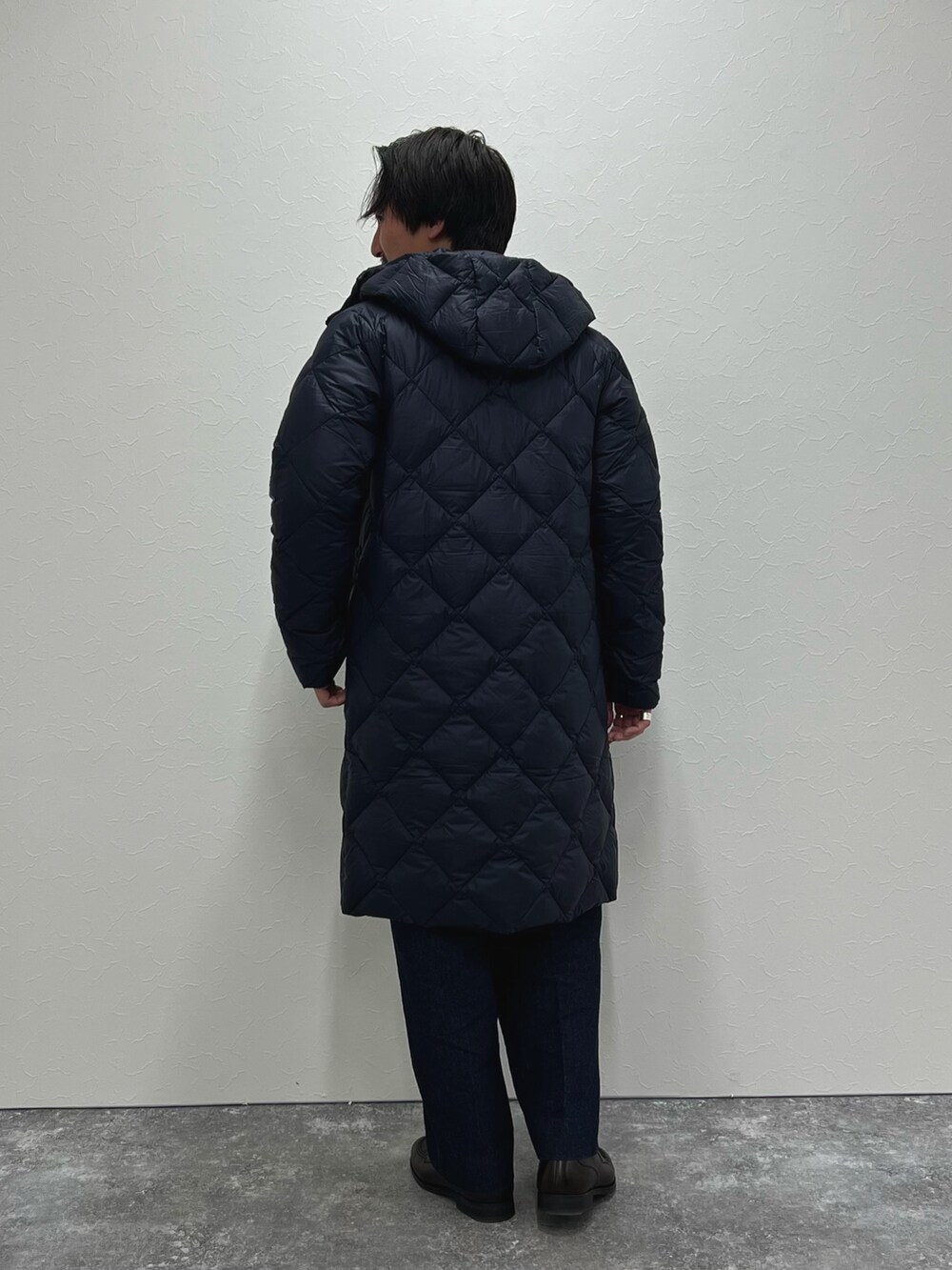 ブルー系のダウンジャケット/コート、グレー系のスウェット、ブルー系のデニムパンツを着用したメンズの冬コーディネートの4枚目の写真