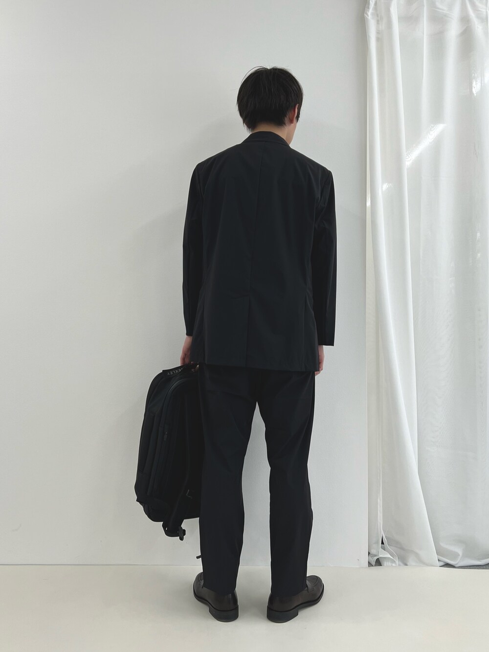 ブラック系のバックパック/リュック、ブルー系のテーラードジャケット、ブルー系のその他パンツを着用したメンズの夏コーディネートの5枚目の写真