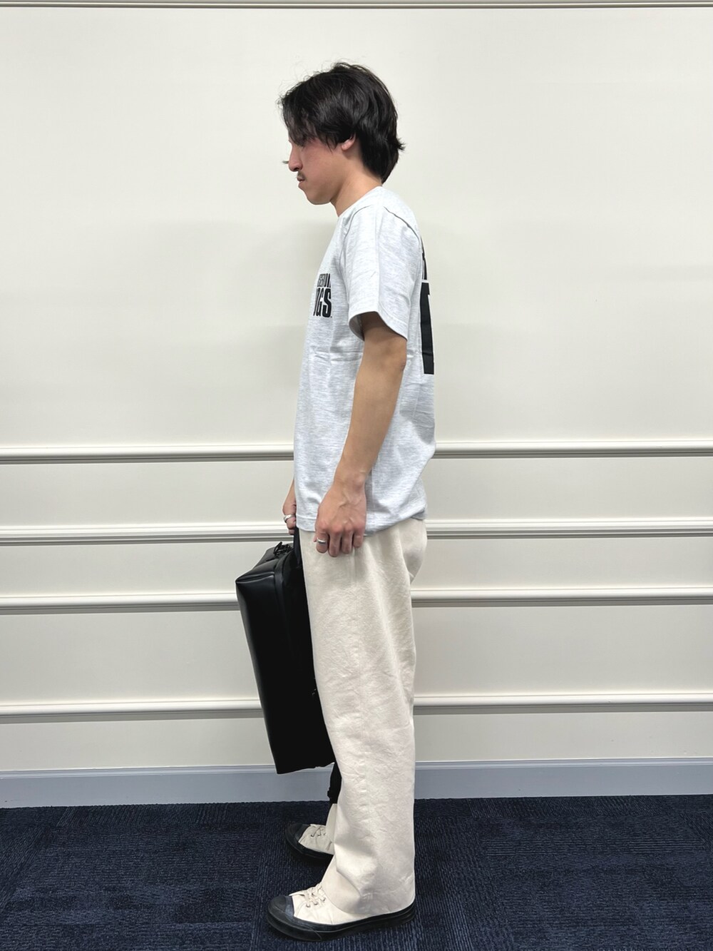 グレー系のTシャツ/カットソー、ブラック系のバックパック/リュック、ホワイト系のデニムパンツを着用したメンズの冬コーディネートの5枚目の写真
