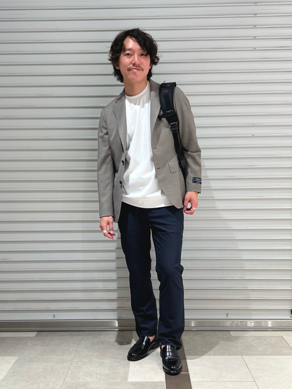 グレー系のテーラードジャケット、ホワイト系のTシャツ/カットソー、ブルー系のその他パンツを着用したメンズの春コーディネートの2枚目の写真