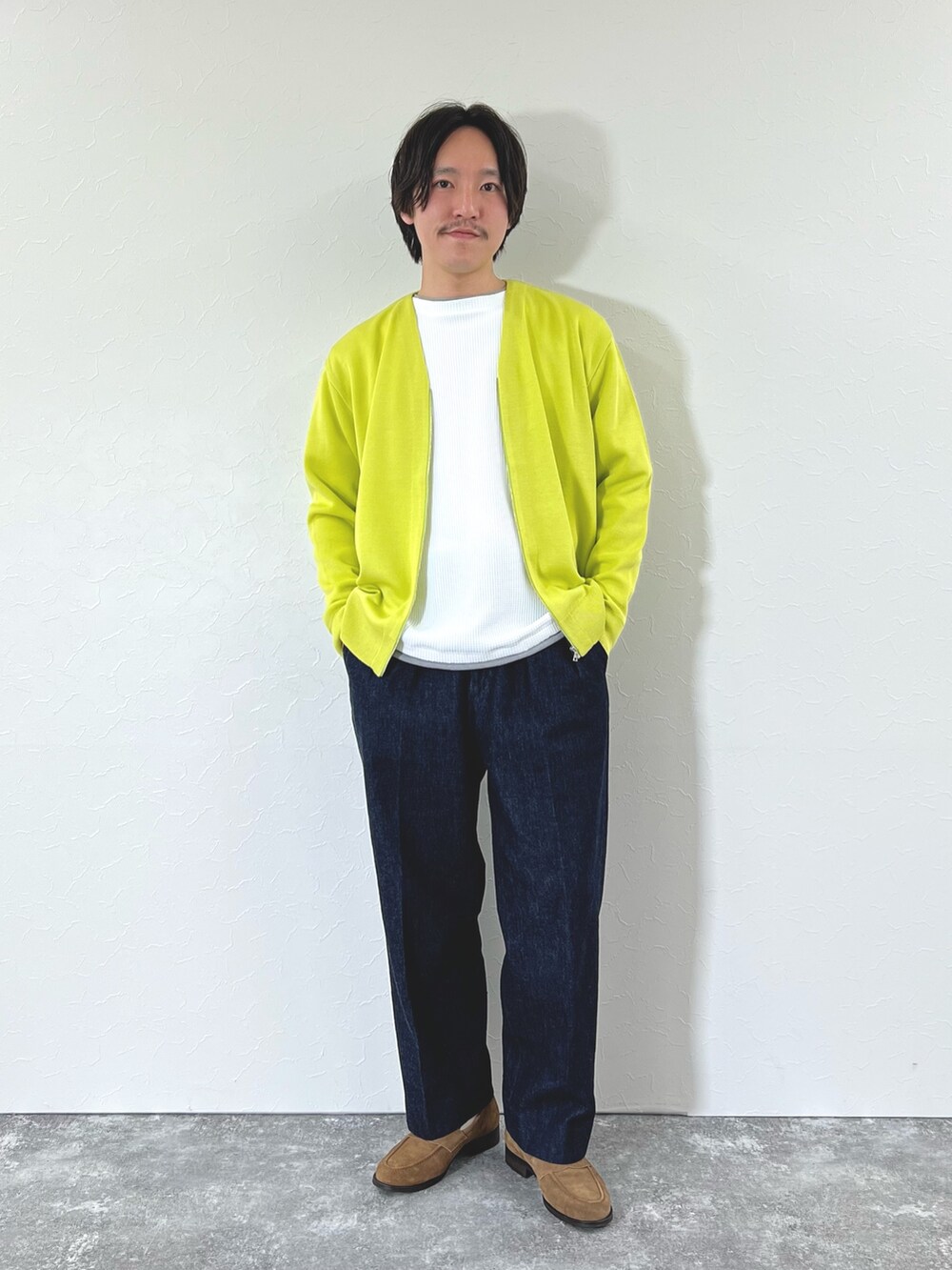 イエロー系のカーディガン/ボレロ、ホワイト系のTシャツ/カットソー、ブルー系のデニムパンツを着用したメンズの冬コーディネートの2枚目の写真