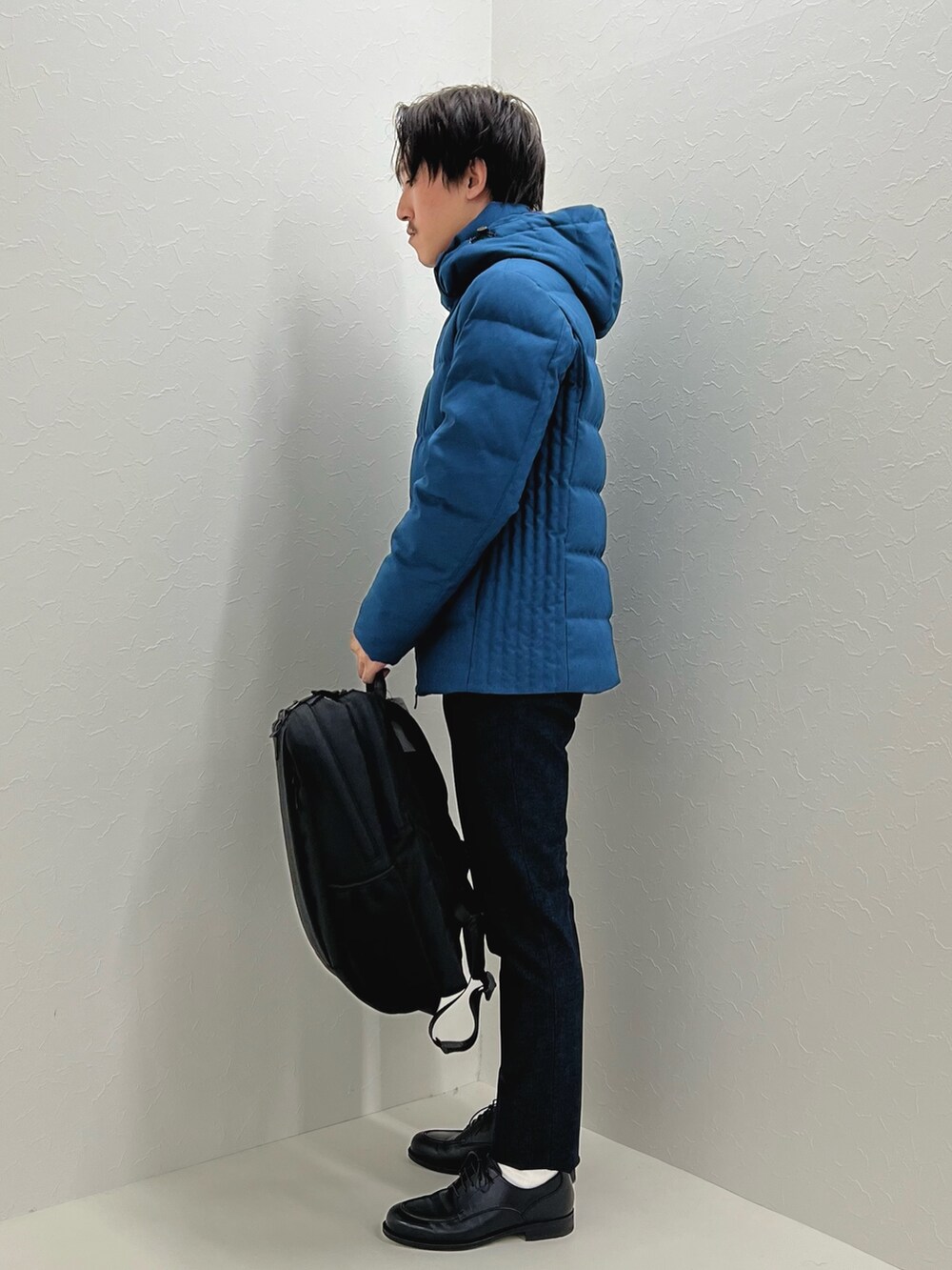 パープル系のニット/セーター、ブルー系のダウンジャケット/コート、ブラック系のバックパック/リュックを着用したメンズの秋コーディネートの4枚目の写真