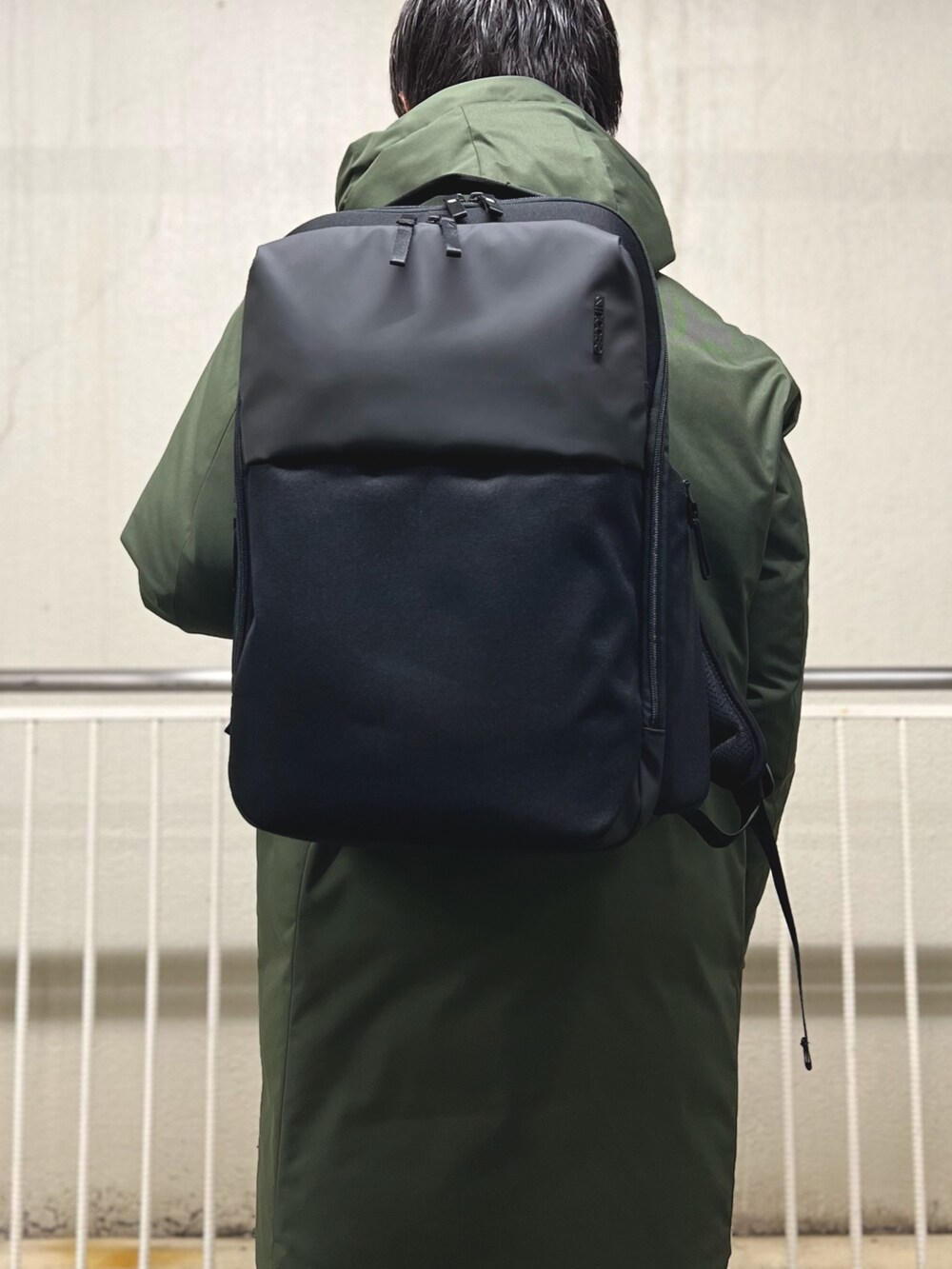 ブルー系のネクタイ、ブラック系のテーラードジャケット、グリーン系のダウンジャケット/コートを着用したメンズの冬コーディネートの8枚目の写真