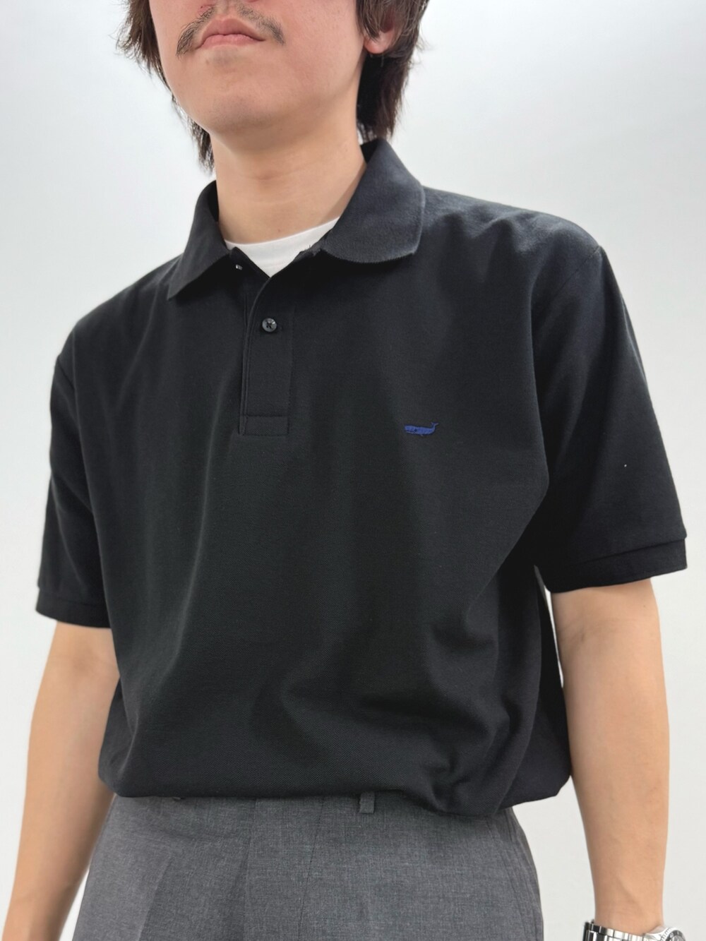 ブラック系のポロシャツ、ブラック系のショルダーバッグ、ブラック系のサンダルを着用したメンズの春コーディネートの7枚目の写真