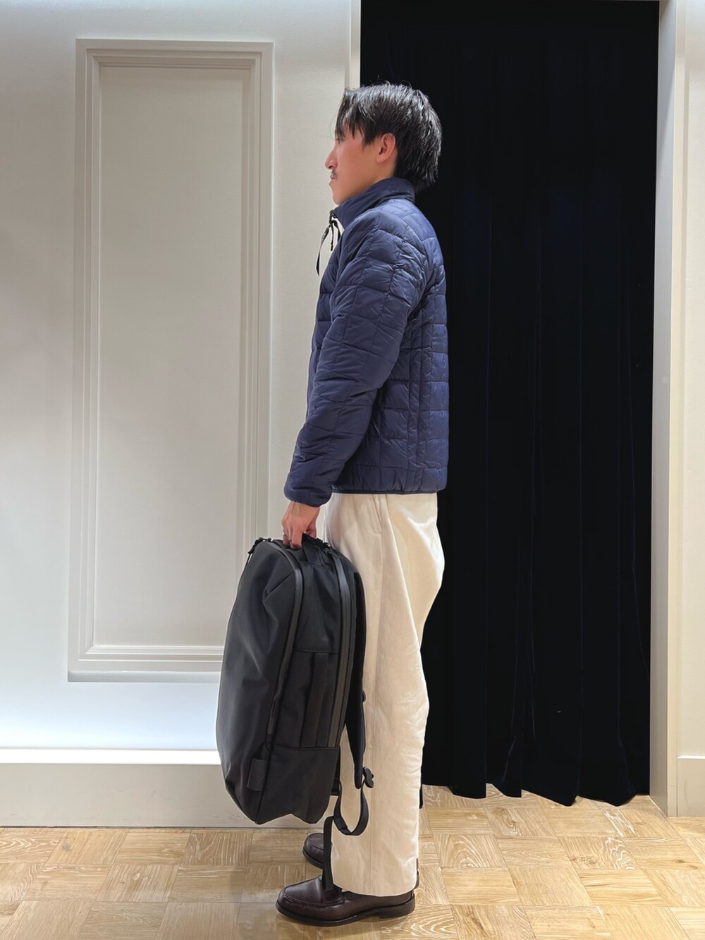 ホワイト系のダウンジャケット/コート、ブラック系のバックパック/リュックを着用したメンズの冬コーディネートの3枚目の写真