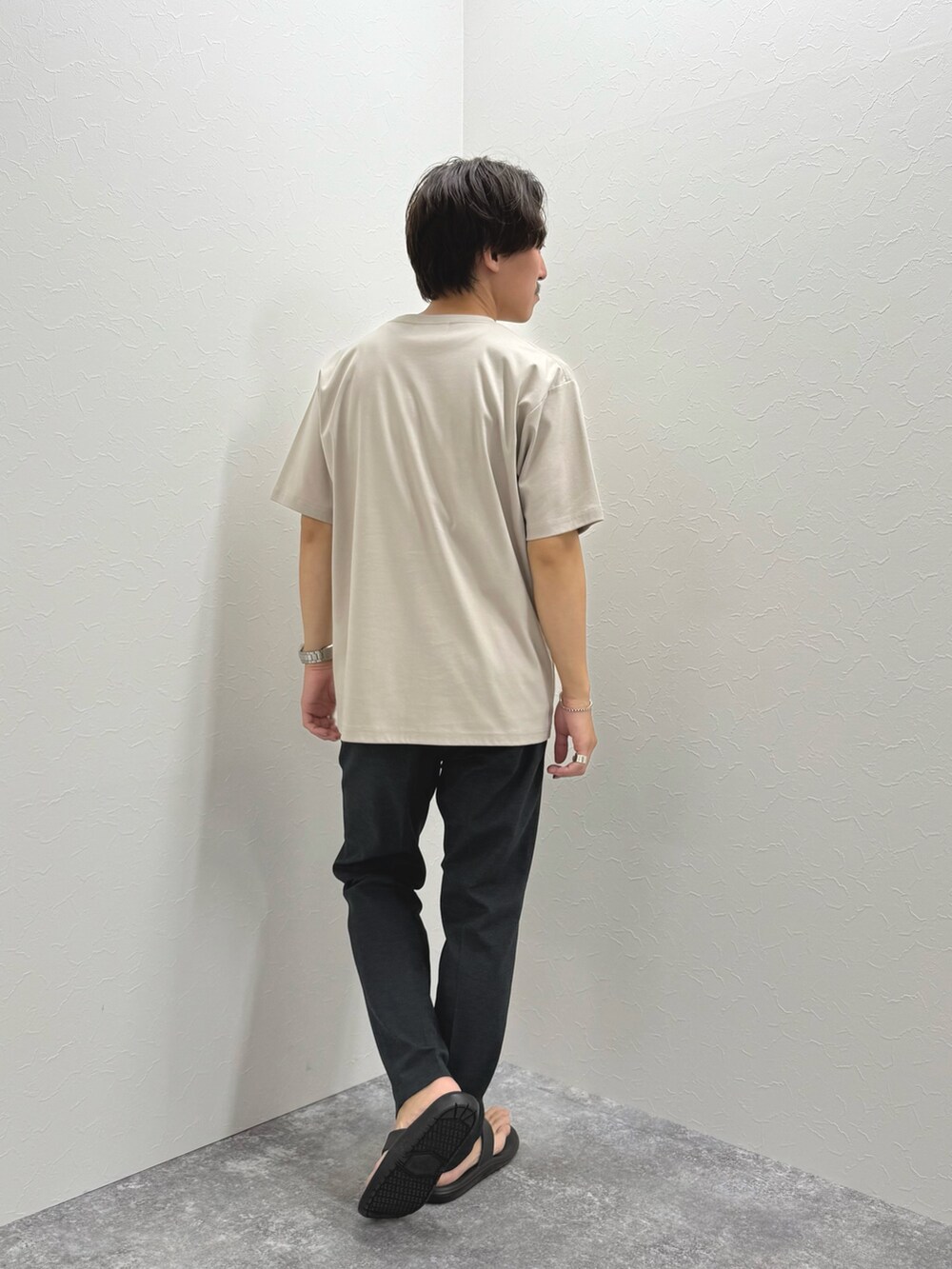 ベージュ系のTシャツ/カットソー、グレー系のその他パンツ、ブラック系のサンダルを着用したメンズの夏コーディネートの5枚目の写真