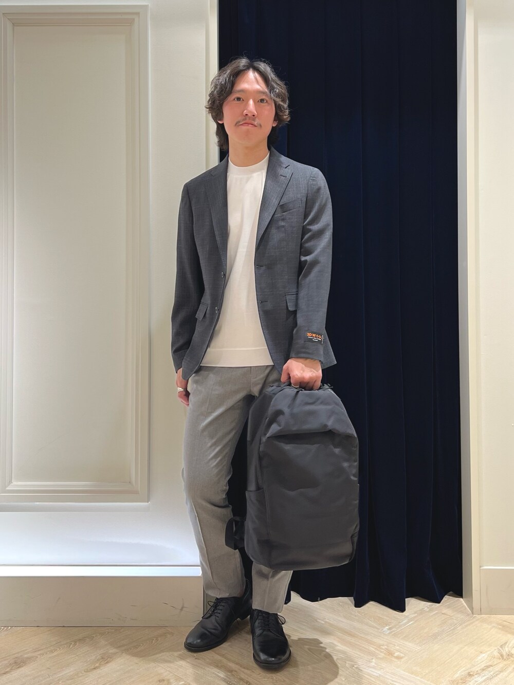 グレー系のテーラードジャケット、ホワイト系のTシャツ/カットソー、グレー系のチノパンツを着用したメンズの春コーディネートの5枚目の写真