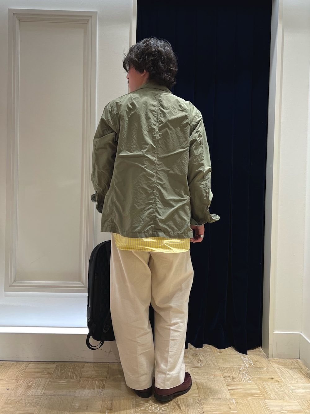 グリーン系のミリタリージャケット、レッド系のローファー、ホワイト系のデニムパンツを着用したメンズの春コーディネートの5枚目の写真