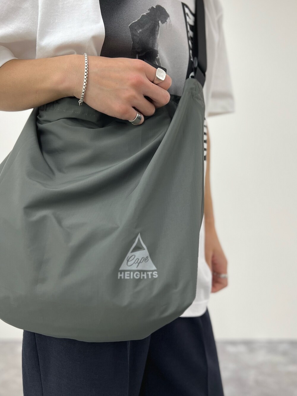 ホワイト系のTシャツ/カットソー、グレー系のトートバッグ、ブルー系のその他パンツを着用したメンズの春コーディネートの6枚目の写真