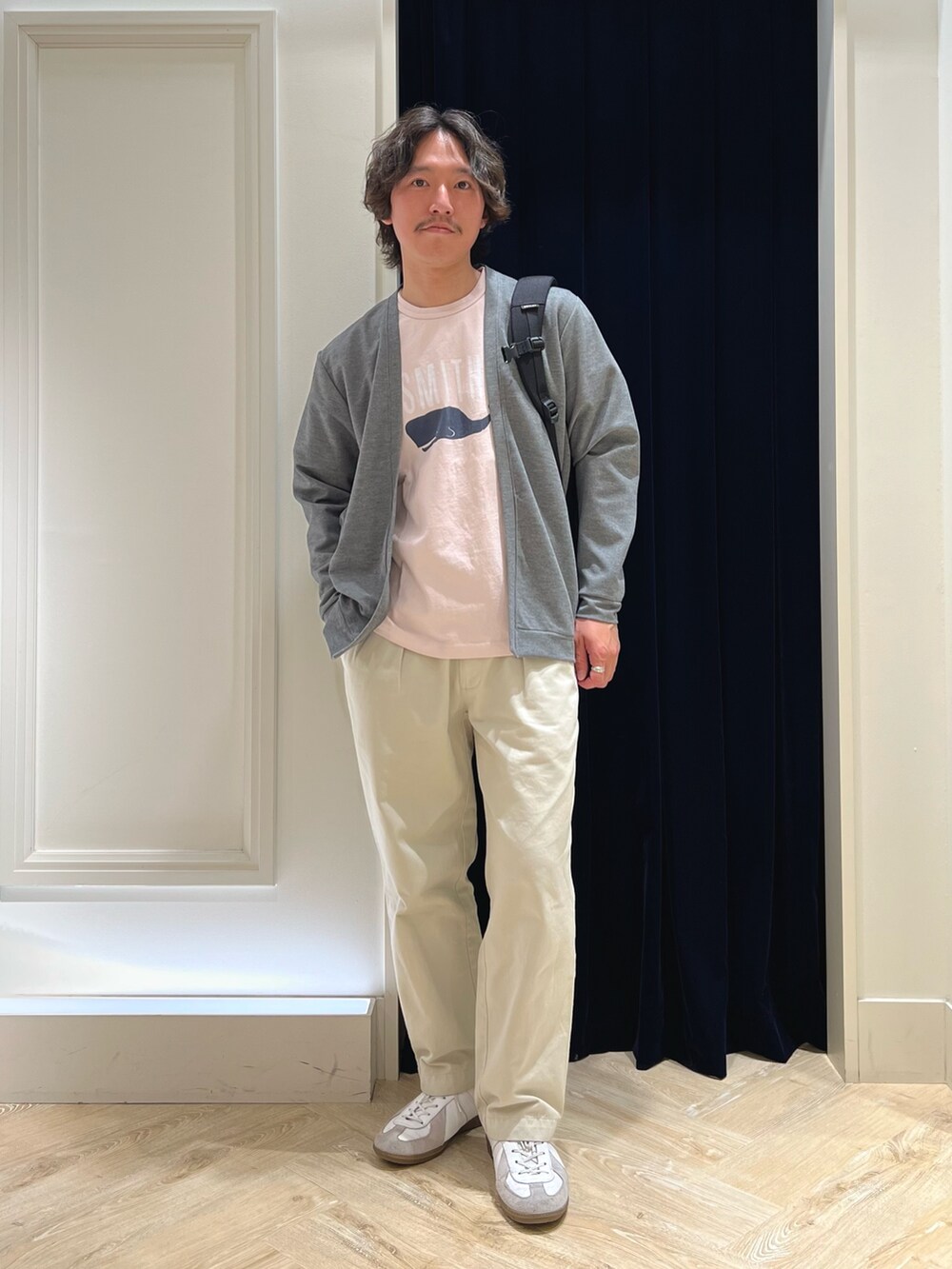 グレー系のカーディガン/ボレロ、ピンク系のTシャツ/カットソー、ブラック系のバックパック/リュックを着用したメンズの春コーディネートの3枚目の写真