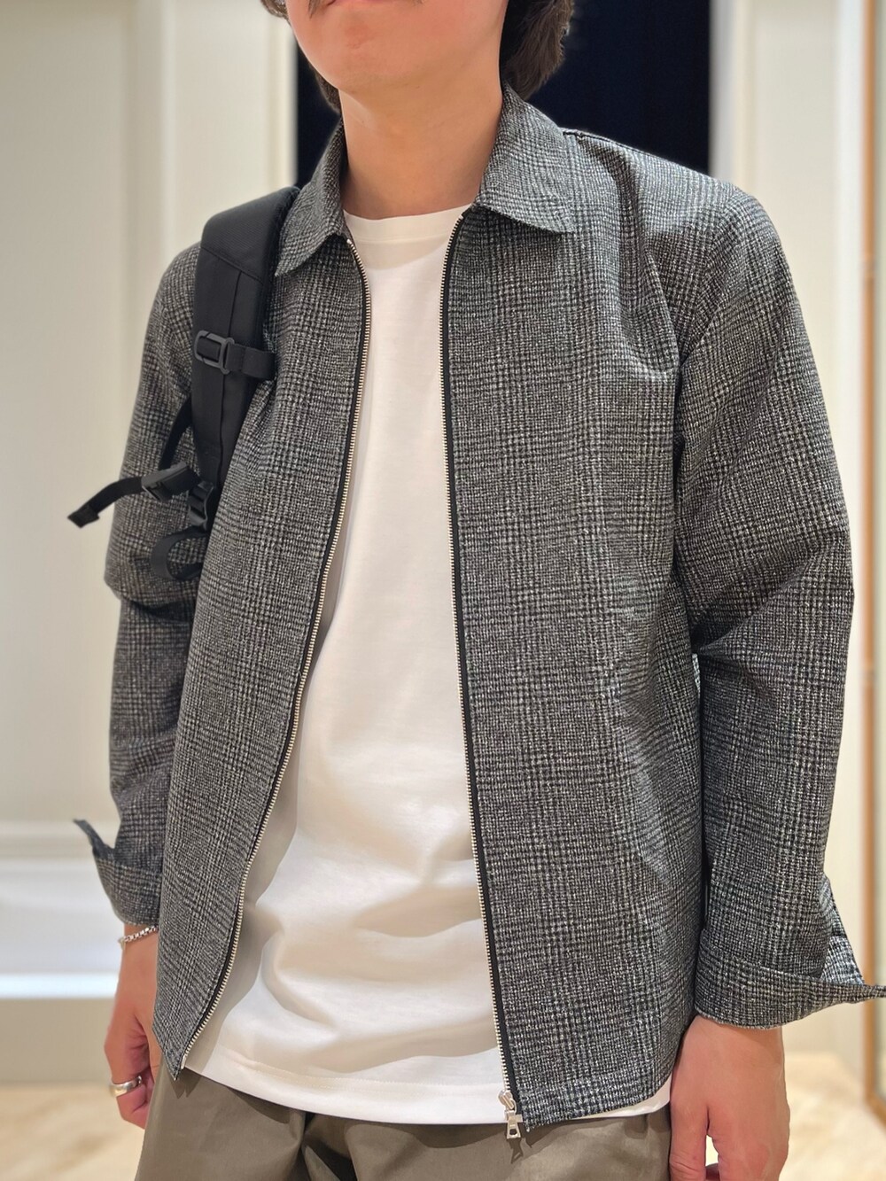 グレー系のブルゾン、ホワイト系のTシャツ/カットソー、ブラック系のバックパック/リュックを着用したメンズの春コーディネートの8枚目の写真