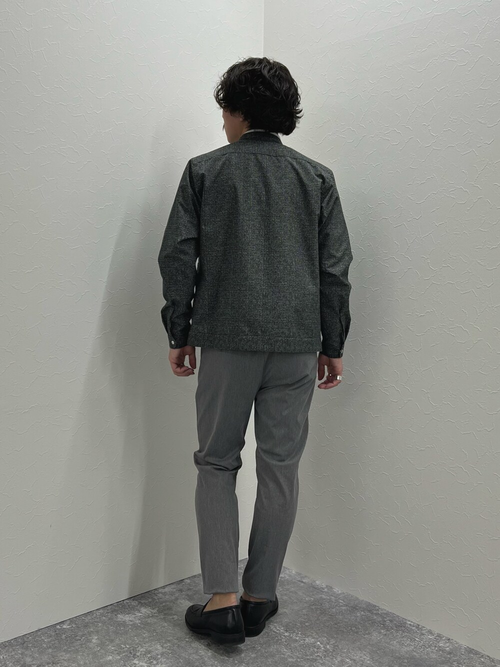 グレー系のブルゾン、ホワイト系のTシャツ/カットソー、グレー系のチノパンツを着用したメンズの冬コーディネートの6枚目の写真