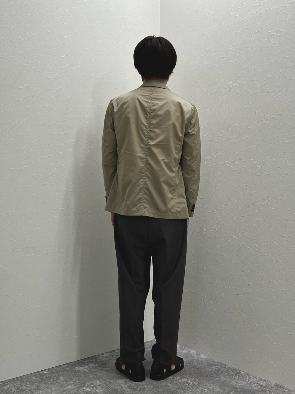 ベージュ系のテーラードジャケット、ホワイト系のTシャツ/カットソー、ブラック系のサンダルを着用したメンズの春コーディネートの5枚目の写真