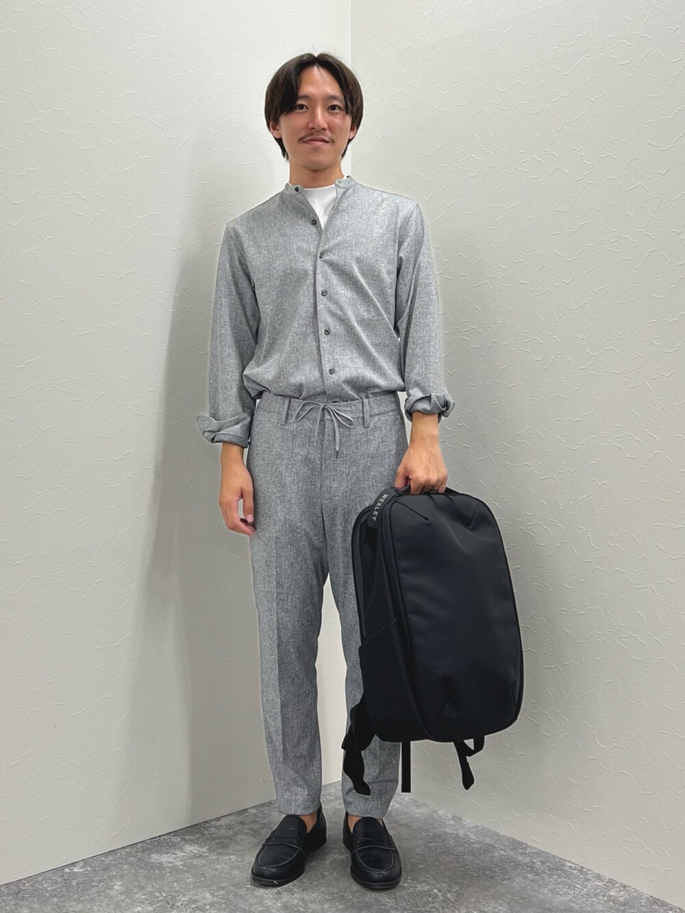 グレー系のその他パンツ、ブラック系のバックパック/リュック、グレー系のシャツ/ブラウスを着用したメンズの夏コーディネートの2枚目の写真