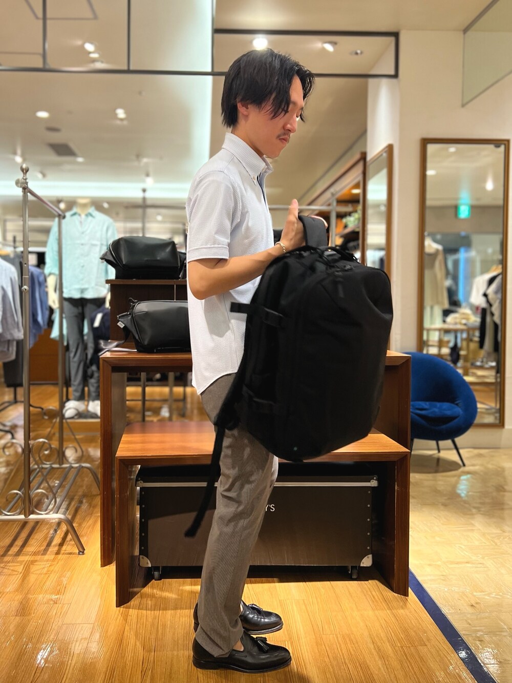 ホワイト系のシャツ/ブラウス、ブラック系のバックパック/リュック、ブルー系のその他パンツを着用したメンズの夏コーディネートの4枚目の写真